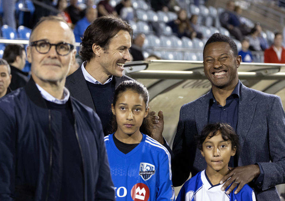 Patrice Bernier, right, is all smiles as he watches a highlight reel before being inducted into the CF Montreal hall of fame, during an MLS soccer game in Montreal, Saturday, May 6, 2023. (Allen McInnis/The Canadian Press via AP)