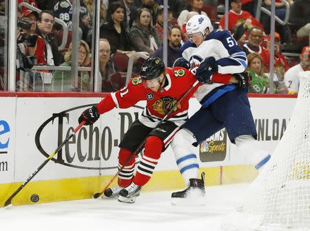 Apr 1, 2019; Chicago, IL, USA; Chicago Blackhawks center Drake Caggiula (91) and Winnipeg Jets defenseman Tyler Myers (57) battle for the puck during the first period at United Center. Mandatory Credit: Nuccio DiNuzzo-USA TODAY Sports