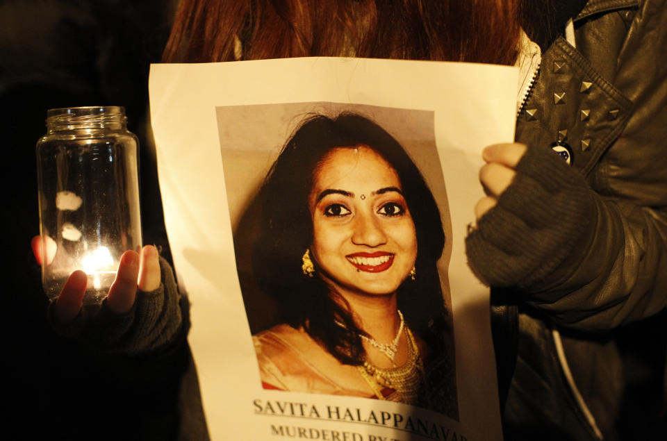 FILE - This Thursday Nov. 15, 2012 file photo shows a woman holding a picture of Savita Halappanava during a candlelit vigil outside Belfast City Hall, Northern Ireland, for Savita Halappanavar, the 31-year old Indian woman who was 17-weeks pregnant when she died of blood poisoning after suffering a miscarriage in Galway, Ireland, on 28 October. Ireland appeared on course to legalize abortion in extremely restricted circumstances as lawmakers voted Tuesday July 2, 2013 to support a bill that would permit pregnancies to be terminated when deemed necessary to save the woman's life. (AP Photo/Peter Morrison, File)