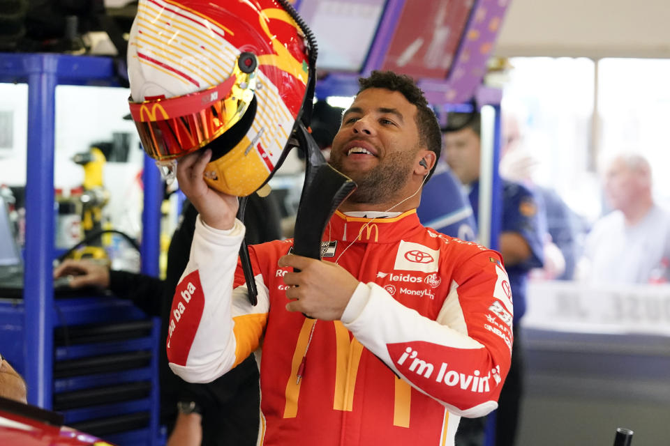 Bubba Wallace puts on his helmet as he prepares for NASCAR Cup Series auto race practice at Daytona International Speedway, Tuesday, Feb. 15, 2022, in Daytona Beach, Fla. (AP Photo/John Raoux)