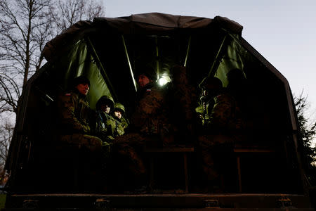 Recruits wait on a truck to go on a shooting range during their 16-day basic training for Poland's Territorial Defence Forces, at a military unit in Siedlce, Poland, December 8, 2017. REUTERS/Kacper Pempel/Files