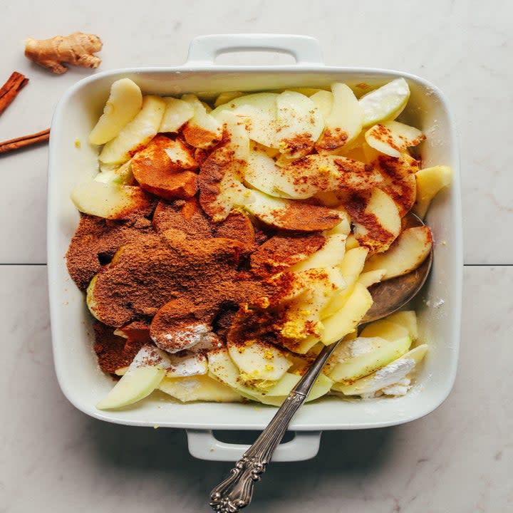 Sliced apples and spices in a casserole dish, before baking