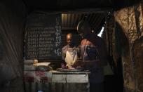 <h2>Chopping food in Nairobi</h2>Denis Onyango Olang, (R), a 26 year-old assistant cook, prepares food in a dimly lit kitchen at a hotel in Nairobi's Kibera slum in the Kenyan capital April 30, 2012. Onyango Olang studied statistics and chemistry at Jomo Kenyatta University of Agriculture and Technology where he received a degree in science. He has been searching for permanent employment for two years but has decided to make a living working in the slums for the last eight months.