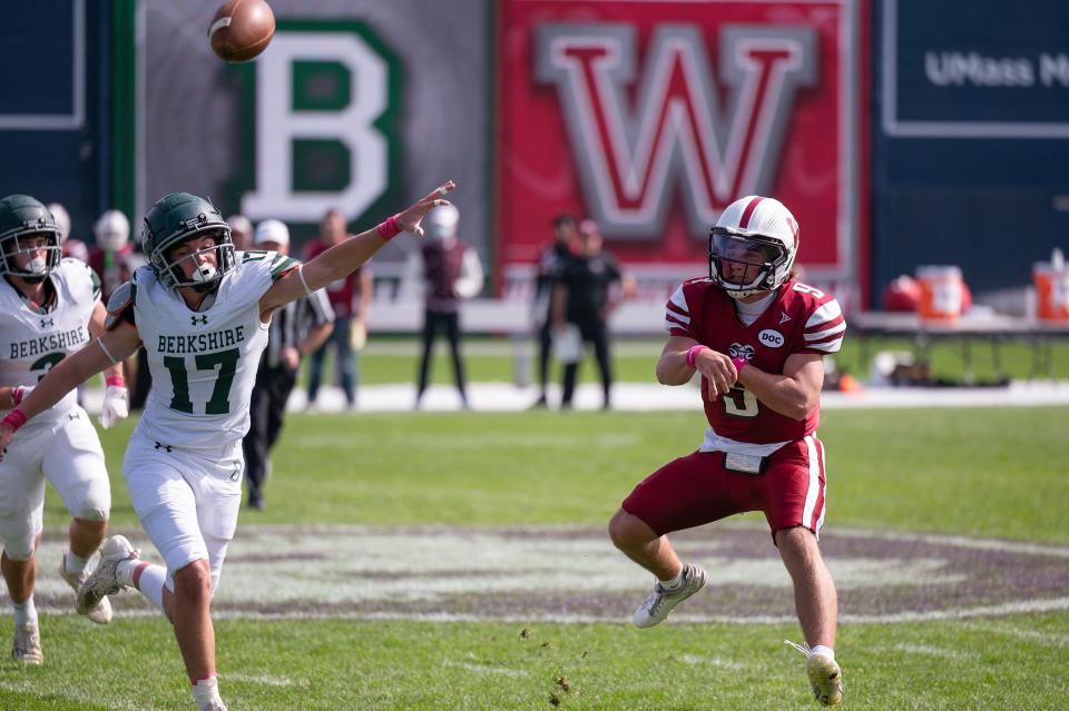 Worcester Academy quarterback Charlie Arvanigian throws over a leaping Berkshire School's Ryan Zouaoui at Polar Park.