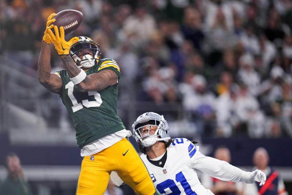 Green Bay Packers wide receiver Dontayvion Wicks (13) makes a touchdown catch in front of Dallas Cowboys cornerback Stephon Gilmore during the first half of an NFL football game, Sunday, Jan. 14, 2024, in Arlington, Texas. (AP Photo/Sam Hodde)