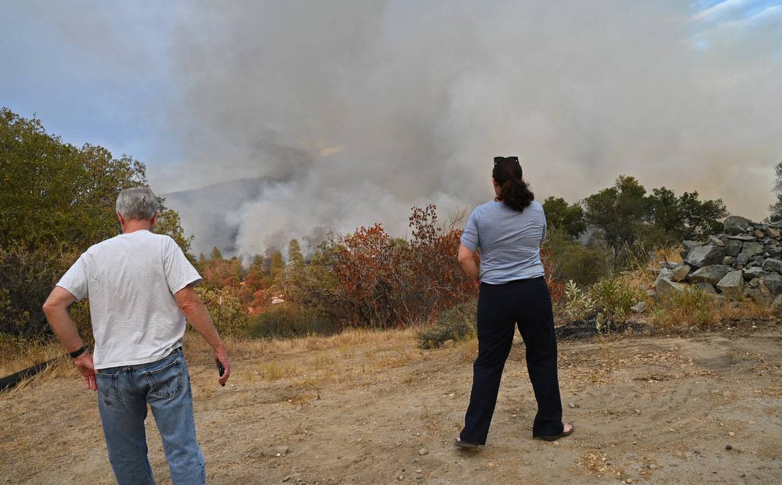 Dan Walker, left, and Jessica Scharffenberg, right, watch as the Fork Fire burns near North Fork on Wednesday, Sept. 7, 2022.