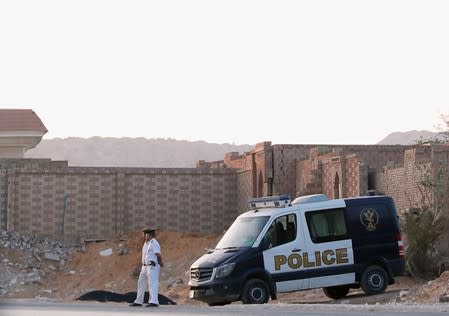 Policemen guard outside the cemetary where the lawyers of ousted Egyptian Islamist President Mohamed Mursi say he was buried, early morning in Cairo