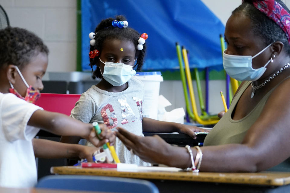 Charisma Edwards, 5, center, checks art work during a class at Chalmers Elementary school in Chicago, Wednesday, July 13, 2022. America's big cities are seeing their schools shrink, with more and more of their schools serving small numbers of students. Those small schools are expensive to run and often still can't offer everything students need (now more than ever), like nurses and music programs. Chicago and New York City are among the places that have spent COVID relief money to keep schools open, prioritizing stability for students and families. But that has come with tradeoffs. And as federal funds dry up and enrollment falls, it may not be enough to prevent districts from closing schools. (AP Photo/Nam Y. Huh)