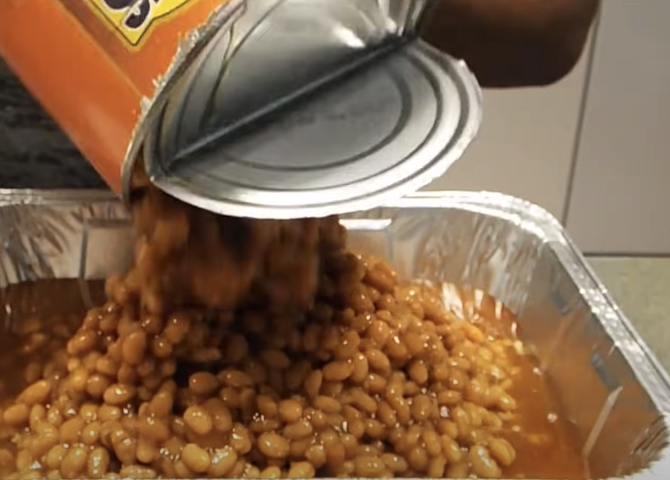 pouring baked beans into baking tin