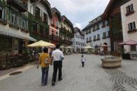 A family walks in the Chinese replica of Austria's UNESCO heritage site, Hallstatt village, in China's southern city of Huizhou in Guangdong province, June 1, 2012.