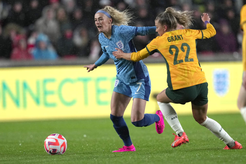 England's Chloe Kelly, left, and Australia's Charlotte Grant fight for the ball during the women's international friendly soccer match between England and Australia at the Gtech Community Stadium in London, England, Tuesday, April 11, 2023. (AP Photo/Kin Cheung)