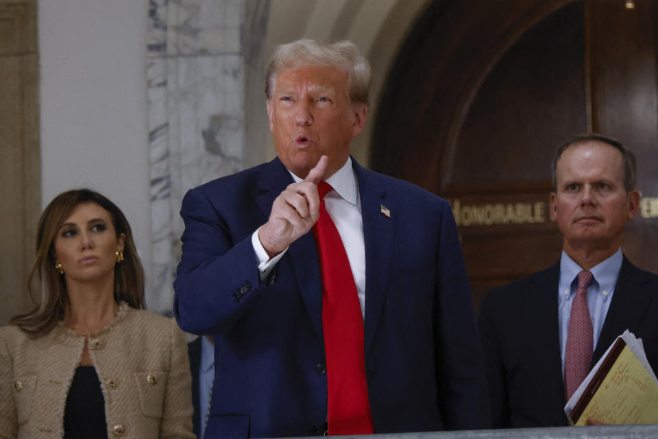 Former President Donald Trump at his civil fraud trial in New York with two lawyers flanking him.