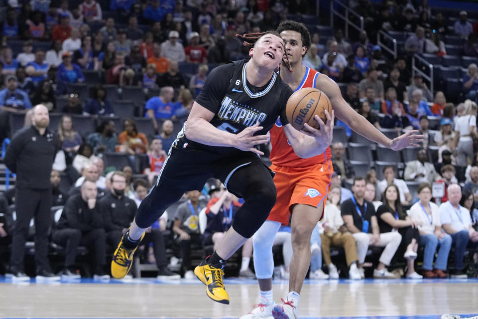 Memphis Grizzlies forward Kenneth Lofton Jr., left, goes to the basket in front of Oklahoma City Thunder forward Jeremiah Robinson-Earl, right, in the second half of an NBA basketball game Sunday, April 9, 2023, in Oklahoma City. (AP Photo/Sue Ogrocki)