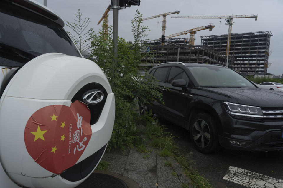 A vehicle with a sticker which reads "Chinese Heart" and "Chinese Dream" is seen near a construction project on the outskirts of Beijing, Thursday, July 25, 2024. (AP Photo/Ng Han Guan)