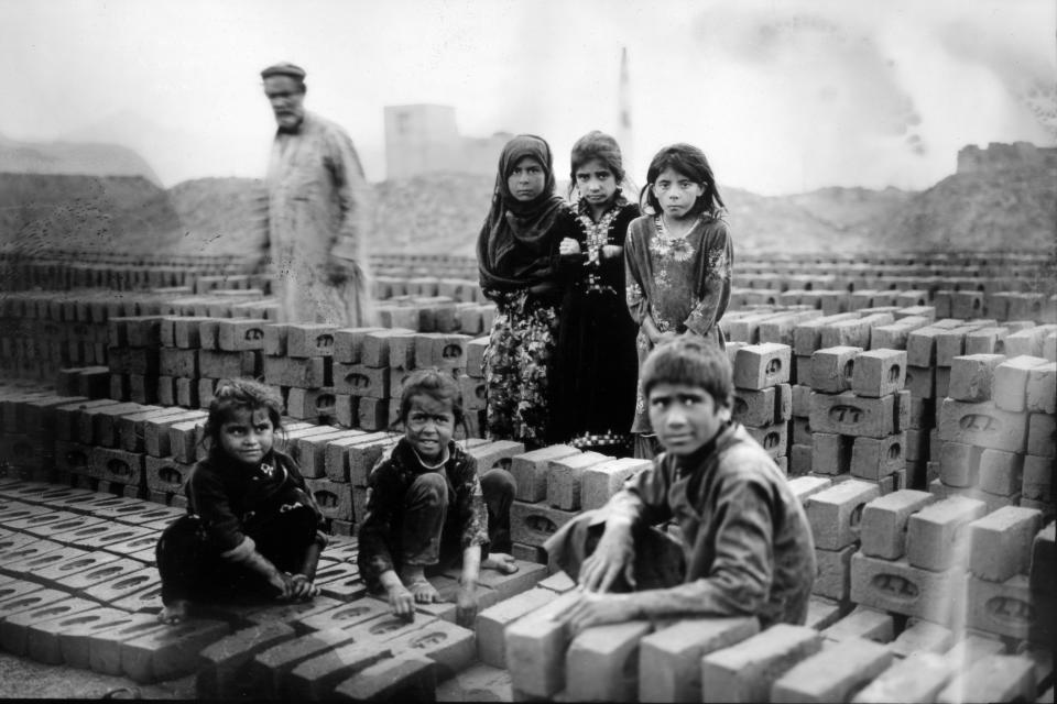 Children, working in a brick factory with their parents, pause for a portrait on the outskirts of Kabul, Afghanistan, Tuesday, May 30, 2023. (AP Photo/Rodrigo Abd)