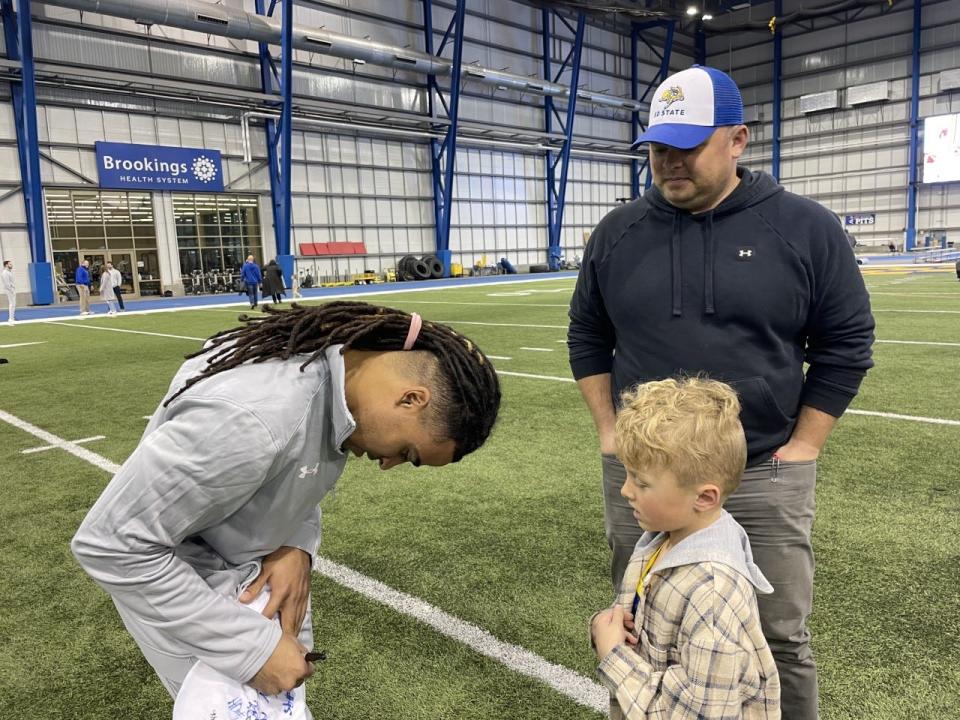 SDSU wide receiver Landon Wolf signs an autograph for a fan at the national championship celebration Tuesday at the SJAC