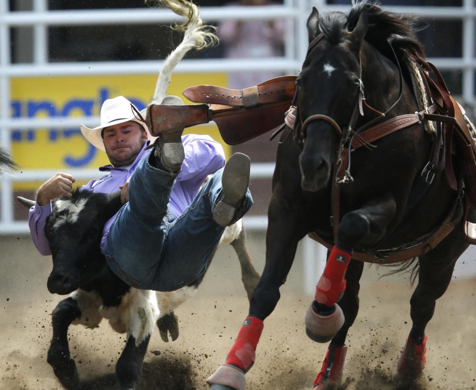 Miller wrestles a steer in a steer wrestling event during day 1 of the rodeo at the 102nd Calgary Stampede in Calgary