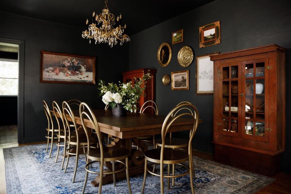 Formal dining gets a twist with black walls, sculptural chairs and subtle metallic accents