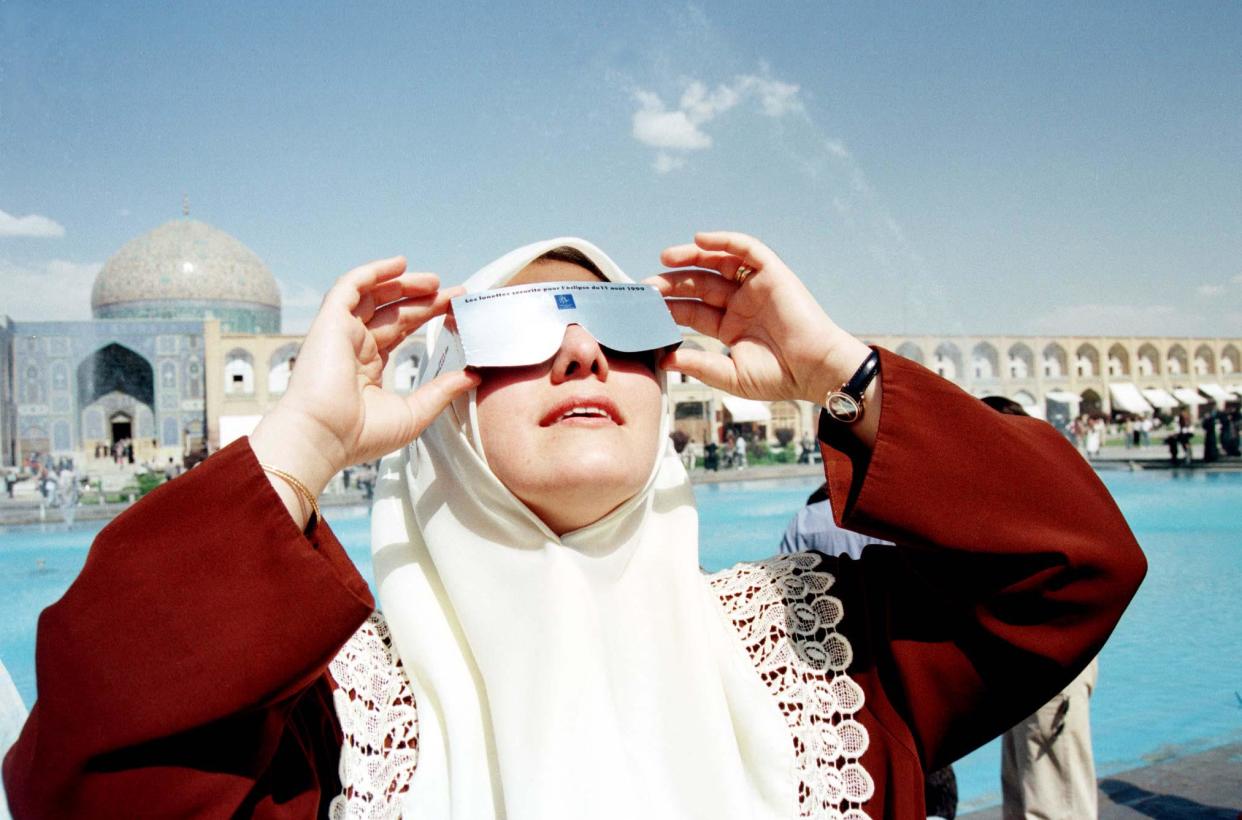 1999: A woman views an eclipse outside a mosque in Isfahan, Iran.