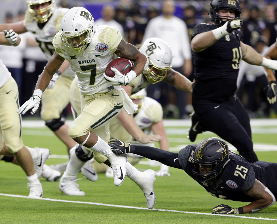 Baylor running back John Lovett (7) slips through the tackle-attempt by Vanderbilt linebacker Josh Smith (25) to score during the first half of the Texas Bowl NCAA college football game Thursday, Dec. 27, 2018, in Houston. (AP Photo/Michael Wyke)