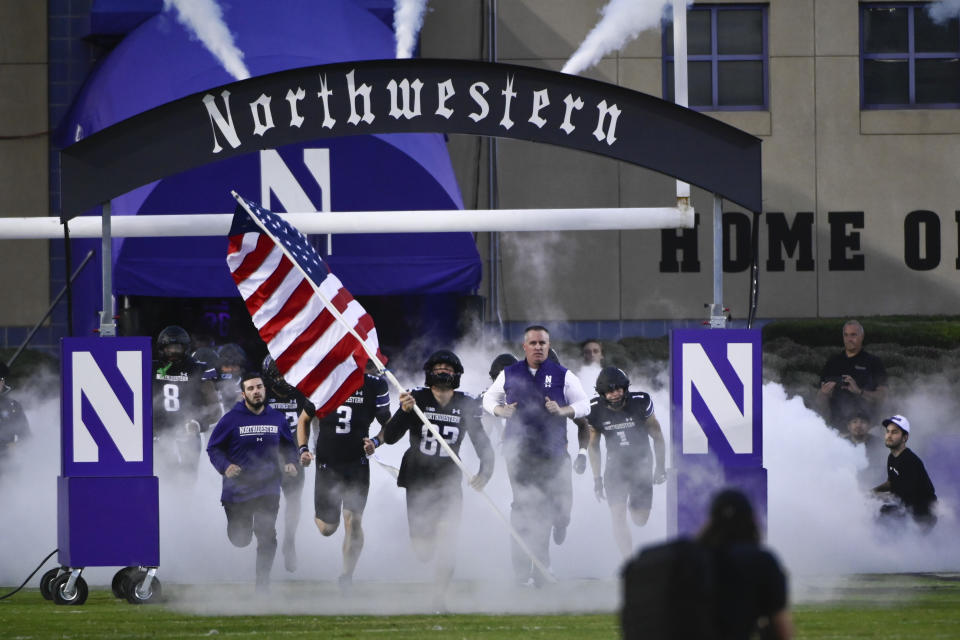 FILE - Northwestern coach Pat Fitzgerald, right, leads the team onto the field for the team's NCAA college football game against Miami (Ohio) on Saturday, Sept. 24, 2022, in Evanston, Ill. At Northwestern, allegations of hazing in the football program led to the firing of longtime coach Pat Fitzgerald, and has the school facing multiple lawsuits with more likely. (AP Photo/Matt Marton, File)