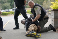 Kevin Burton-Crow, right, of the Thurston Co. Sheriff's Dept., handcuffs Naseem Coaxum, an actor playing the role of a person causing a disturbance at a convenience store, during a training class at the Washington state Criminal Justice Training Commission, Wednesday, July 14, 2021, in Burien, Wash. Washington state is embarking on a massive experiment in police reform and accountability following the racial justice protests that erupted after George Floyd's murder last year, with nearly a dozen new laws that took effect Sunday, July 25, but law enforcement officials remain uncertain about what they require in how officers might respond — or not respond — to certain situations, including active crime scenes and mental health crises. (AP Photo/Ted S. Warren)