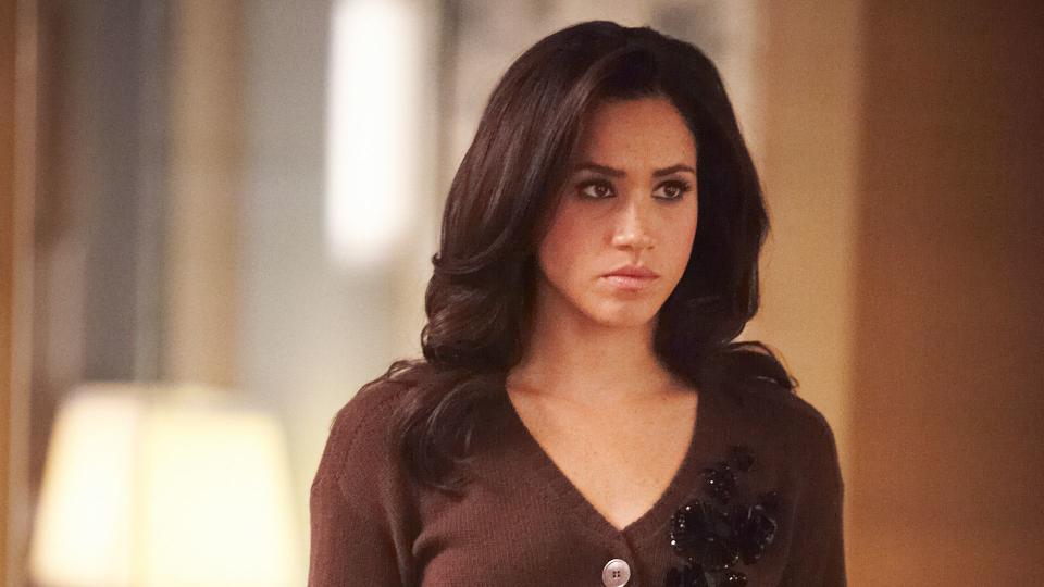 Meghan Markle in character as Rachel Zane in a brown outfit and looking frustrated