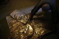 A bas-relief of the late Pope John Paul II, made of bronze, is being worked on in Krakow April 17, 2014.REUTERS/Kacper Pempel