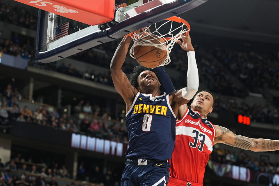 Denver Nuggets forward Peyton Watson, left, is fouled as he dunks the ball for a basket by Washington Wizards forward Kyle Kuzma in the second half of an NBA basketball game Thursday, Feb. 22, 2024, in Denver. (AP Photo/David Zalubowski)