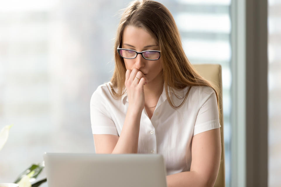 Woman at laptop with serious expression