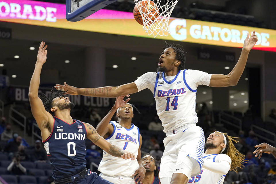 DePaul's Nick Ongenda (14) blocks the shot of Connecticut's Jalen Gaffney (0) as Javan Johnson also defends during the first half of an NCAA college basketball game Saturday, Jan. 29, 2022, in Chicago. (AP Photo/Charles Rex Arbogast)