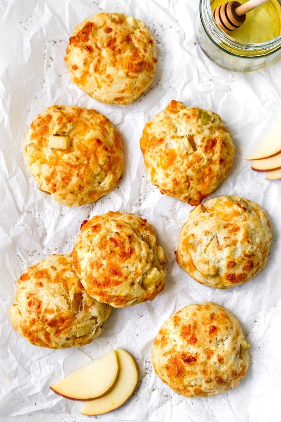 apple cheddar biscuits on a sheet of white parchment paper