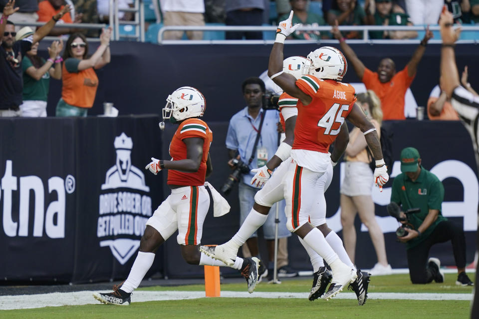 Miami defensive lineman Mitchell Agude (45) celebrates as defensive back Gilbert Frierson, left, scores a touchdown after intercepting the ball during the first half of an NCAA college football game against Bethune Cookman, Saturday, Sept. 3, 2022, in Miami Gardens, Fla. (AP Photo/Lynne Sladky)