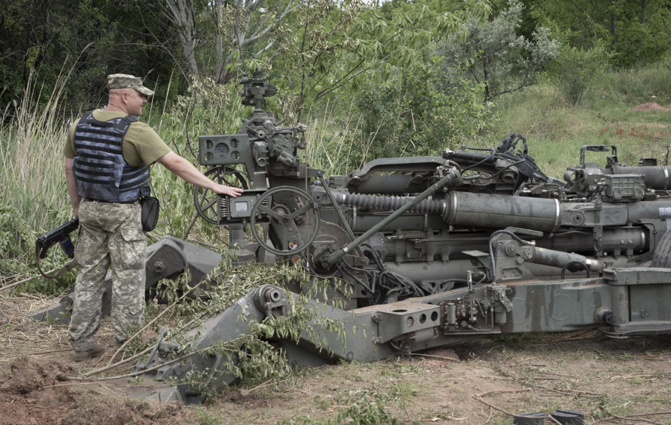 A Ukrainian soldier stands at a U.S.-supplied M777 howitzer in Ukraine's eastern Donetsk region Saturday, June 18, 2022. (AP Photo/Efrem Lukatsky)