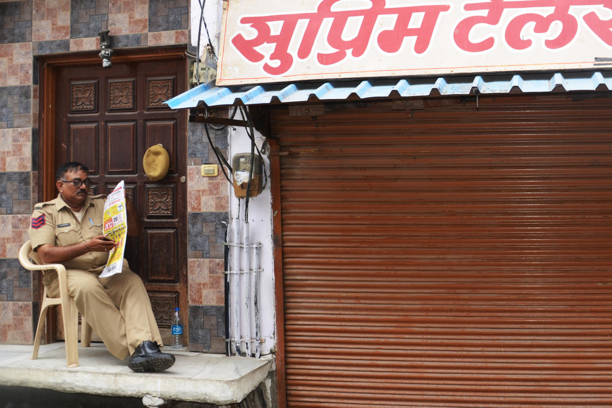An officer guards Teli’s shop in Udaipur. (Yashraj Sharma)
