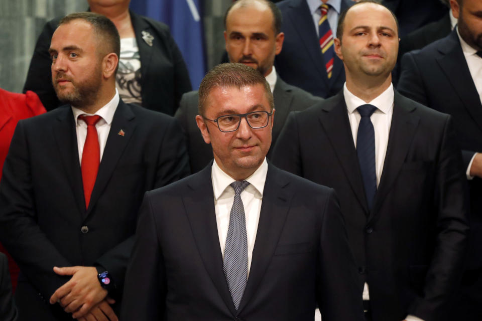 Hristijan Mickoski, center front, the new North Macedonia's prime minister and the members of his cabinet stand together for a photo after the parliament elected the new government, in the parliament building in Skopje, North Macedonia, late Sunday, June 23, 2024. North Macedonia's parliament has approved a new conservative government late on Sunday proposed by a center-right party that won May's national elections. (AP Photo/Boris Grdanoski)