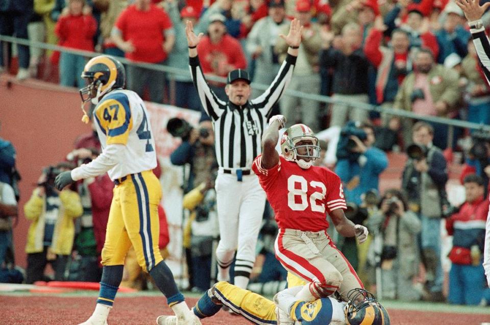 San Francisco 49ers wide receiver John Taylor sits atop Los Angeles Rams safety James Washington as he celebrates a touchdown pass from Joe Montana in the second quarter at Candlestick Park, Sunday, Jan. 15, 1990, San Francisco, Calif. The 49ers beat the Rams 30-3 to head to the Super Bowl in New Orleans. (AP Photo/Bob Galbraith)