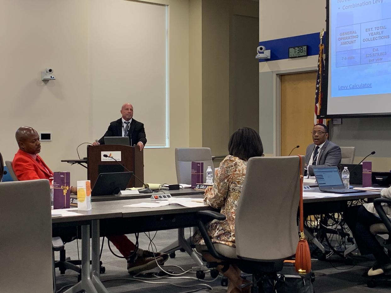 Superintendent Michael Robinson (right) talks to the board about impending budget cuts at the May 6 regular school board meeting.