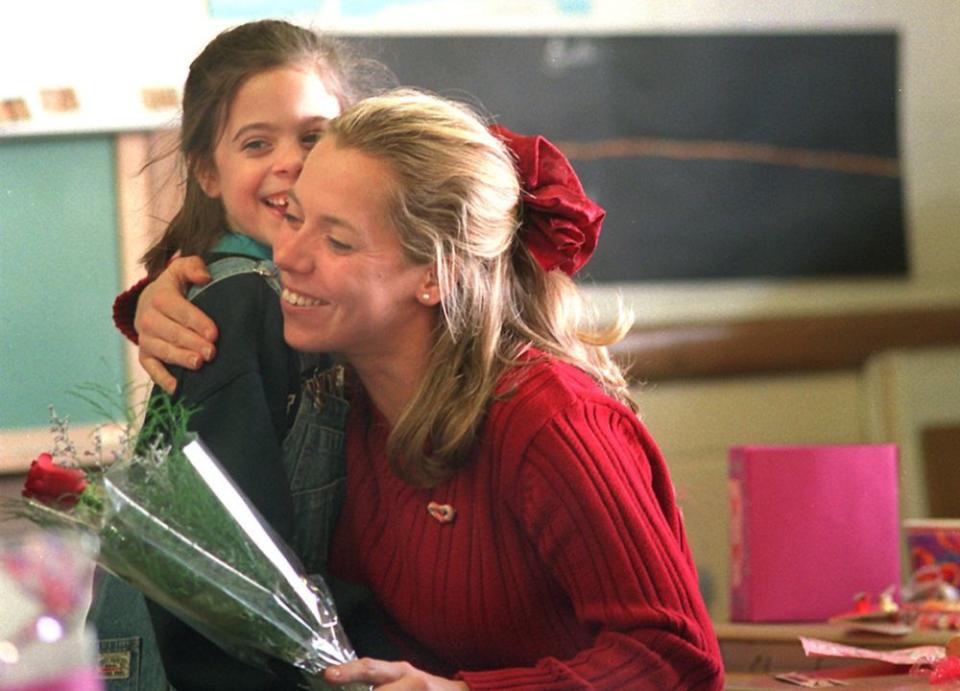 <em>Second grader Vanessa Fede gets a hug from her teacher, Karla Garvin, at the Miller Elementary School after presenting her with a rose during a class Valentine’s Day party in 1998</em>. (Getty Images)