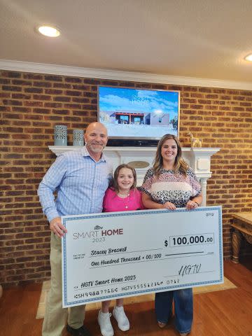 <p>HGTV</p> Stacey Braswell poses with her family after winning the HGTV Smart Home