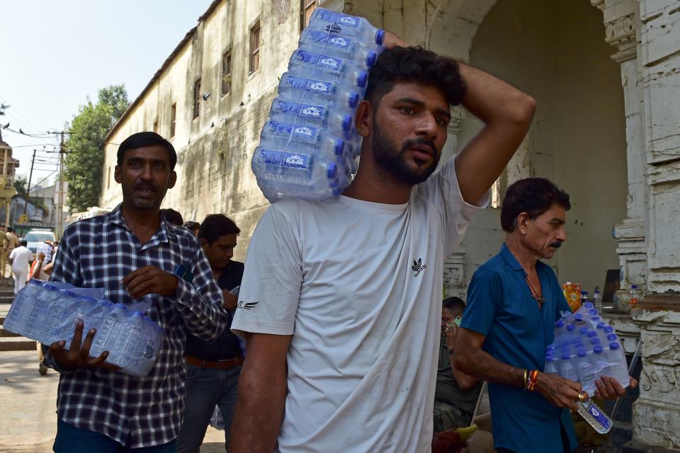 <p>Volunteers carry water bottles for rescue personnel at the site of a bridge collapse at Morbi in India's Gujarat state on October 31, 2022. - At least 137 people died in western India when a colonial-era pedestrian bridge packed with revellers collapsed into the river below, police said on October 31. (Photo by Sam PANTHAKY / AFP) (Photo by SAM PANTHAKY/AFP via Getty Images)</p> 