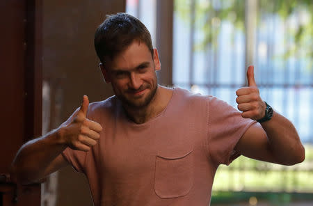 Pyotr Verzilov, one of four intruders affiliated to Russia's Pussy Riot protest group who were jailed for 15 days for staging a pitch invasion during the football World Cup final and were detained again after their release on July 30, gives a double thumb-up outside a court building in Moscow, Russia July 31, 2018. REUTERS/Tatyana Makeyeva/Files