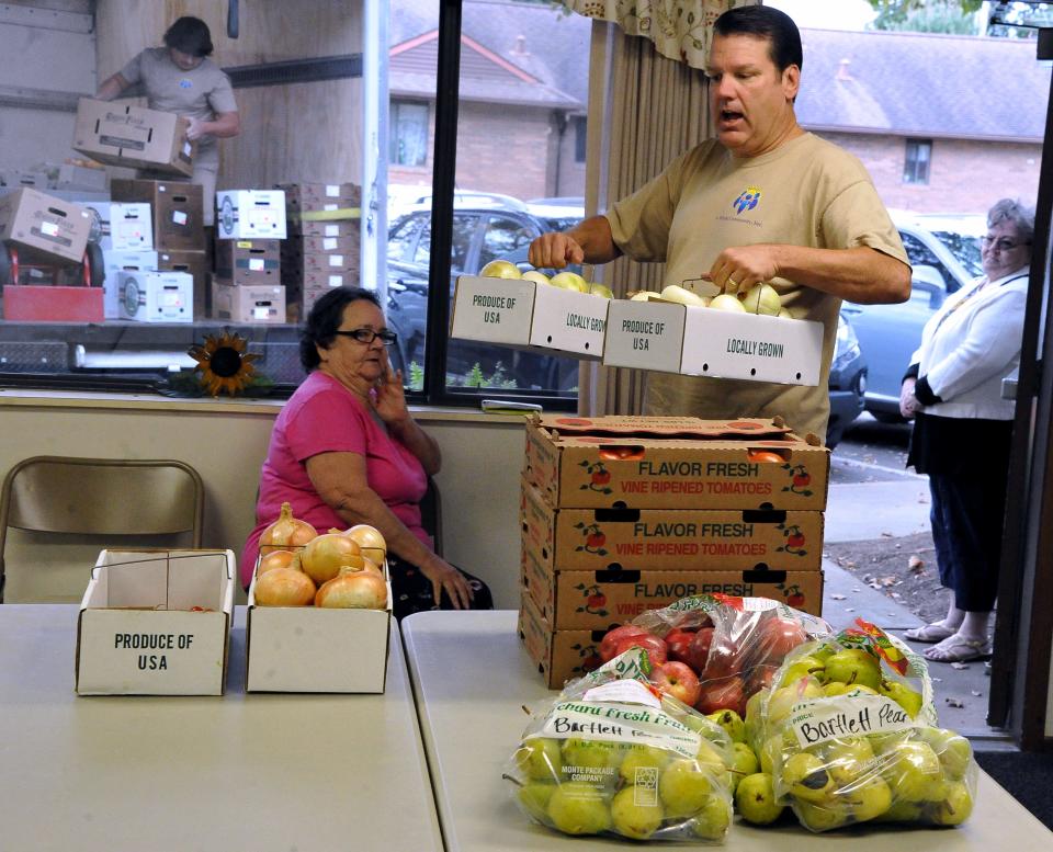 Charles Runion carries in vegetables for residents at OrrVilla's Evergreen Place while Thomas Foster unloads the truck. A Whole Community encourages community members and agencies to contribute what they can in skills, knowledge, money, time or resources as it brings fresh produce to those in need.