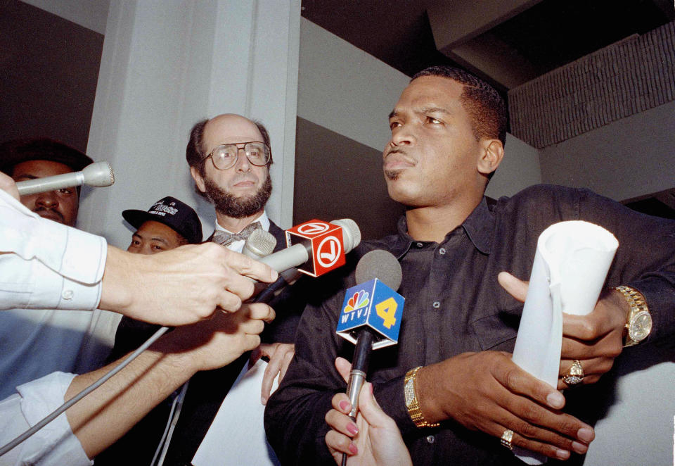 FILE - Luther Campbell, leader of hip hop group of 2 Live Crew, right, holds a copy of a federal judge's order ruling his best-selling album obscene, outside of the federal courthouse in Fort Lauderdale, Fla., June 6, 1990. In the five decades since hip-hop emerged out of New York City, it spread around the country and the world. Mainstream America hasn't always been ready for it. The sexually explicit content from 2 Live Crew made their 1989 album “As Nasty As They Want To Be” the subject of a legal battle over obscenity and freedom of expression; a later album, “Banned in the USA,” became the first to get an official record industry label about explicit content. (AP Photo/Bill Cooke, file)