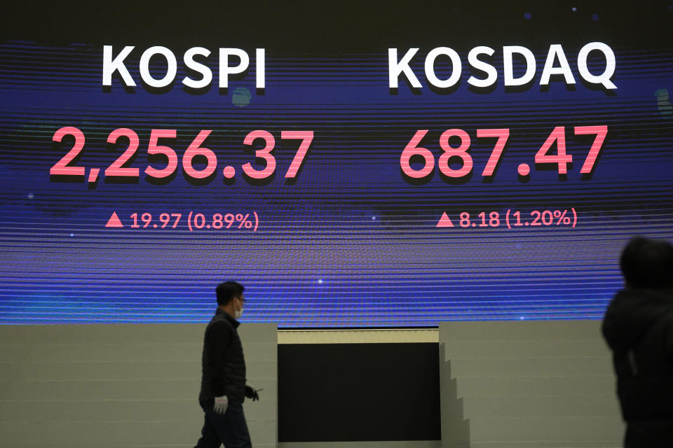 A huge screen shows the Korea Composite Stock Price Index (KOSPI) and the Korean Securities Dealers Automated Quotations (KOSDAQ) as a man walks after the opening ceremony of the 2023 trading year at the Korea Exchange in Seoul, South Korea, Monday, Jan. 2, 2023. Shares began the year mixed on Monday, with most markets closed for New Year holidays. (AP Photo/Lee Jin-man)