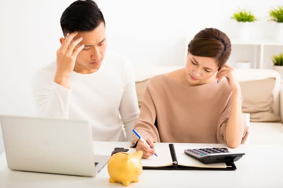 Couple adding up their finances with a calculator