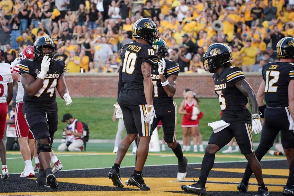 Missouri Tigers wide receiver Mekhi Miller (No. 10, and a Blue Valley North grad) celebrates with teammates after scoring the opening touchdown of Thursday night’s season-opening game against South Dakota on a pass from Brady Cook at Faurot Field in Columbia.