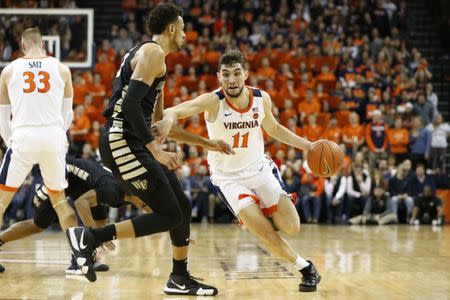 Jan 22, 2019; Charlottesville, VA, USA; Virginia Cavaliers guard Ty Jerome (11) dribbles the ball around Wake Forest Demon Deacons center Olivier Sarr (30) during the second half at John Paul Jones Arena. Mandatory Credit: Amber Searls-USA TODAY Sports