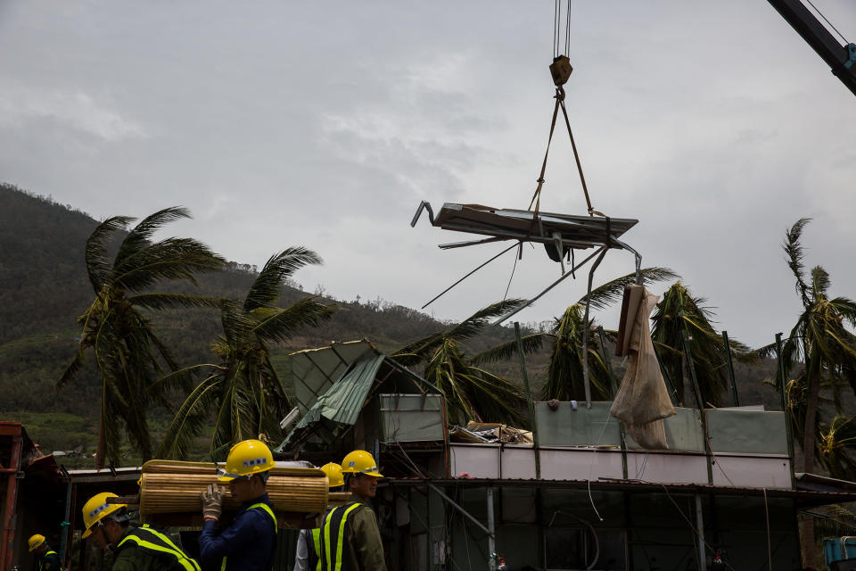 Workers remove a damaged roof damaged by Typhoon Nepartak