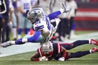 Dallas Cowboys running back Ezekiel Elliott (21) is hit by New England Patriots cornerback Jalen Mills, bottom, during the first half of an NFL football game, Sunday, Oct. 17, 2021, in Foxborough, Mass. (AP Photo/Steven Senne)